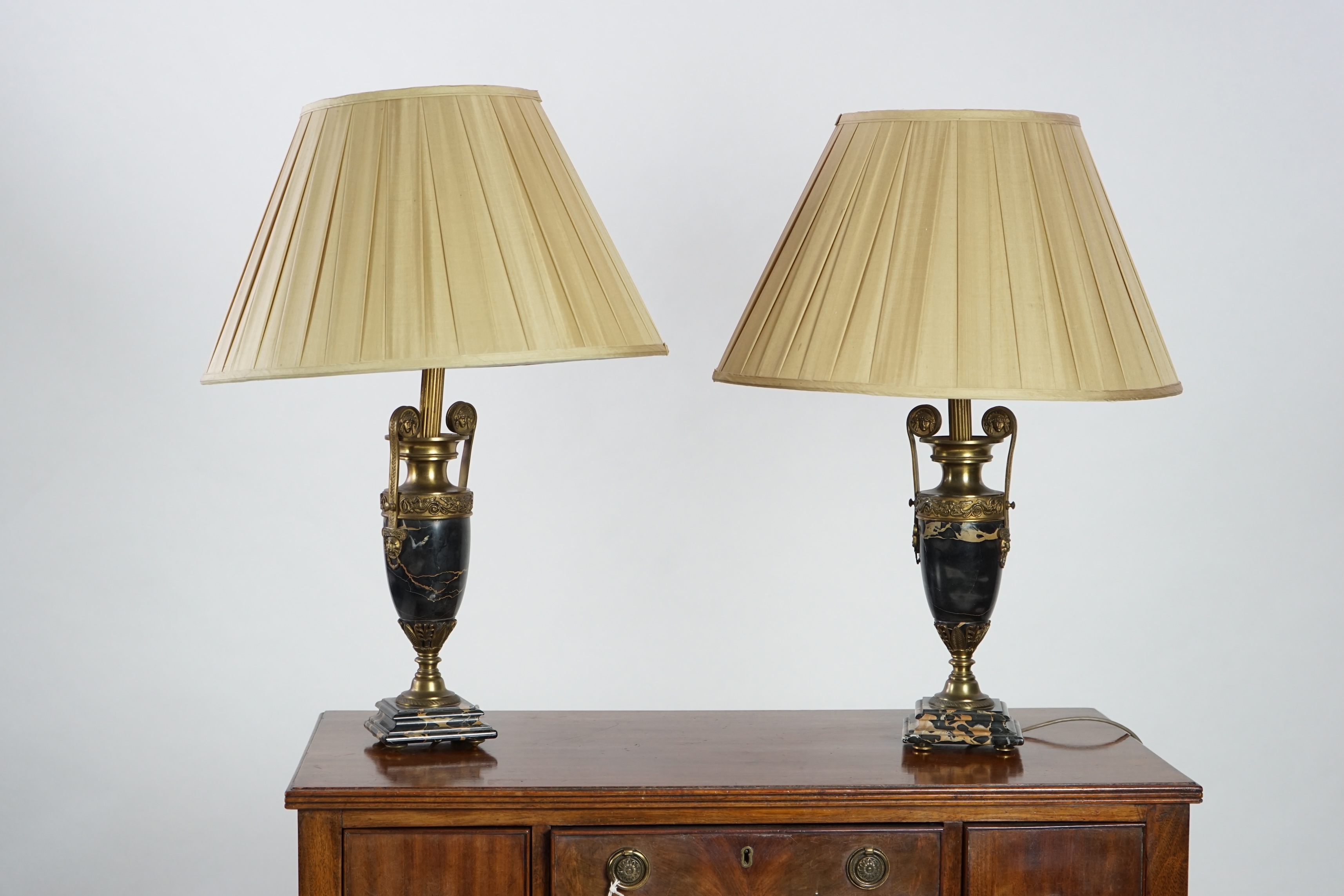 A pair of French Empire style ormolu mounted black marble table lamps